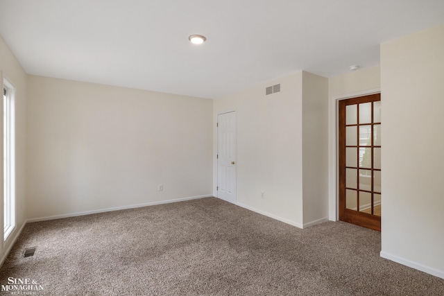 empty room with carpet floors, baseboards, and a smoke detector
