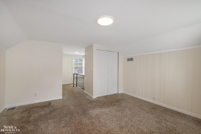 additional living space with vaulted ceiling, carpet flooring, and baseboards