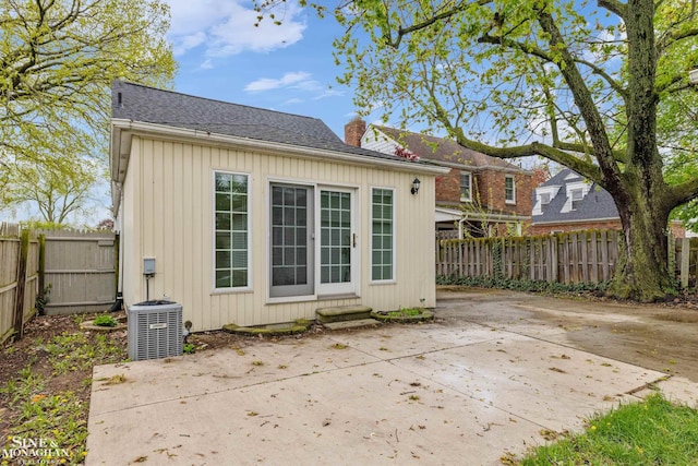 back of house with central AC unit, a patio area, a chimney, and a fenced backyard