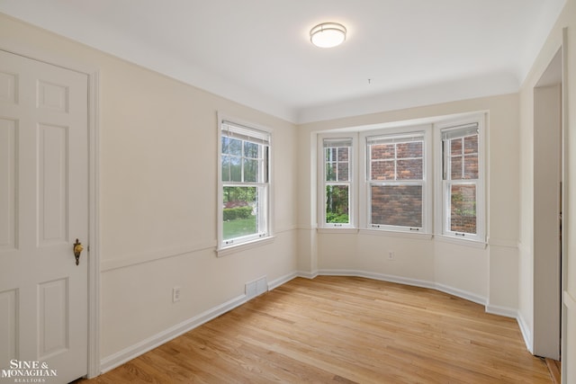 spare room featuring light wood finished floors and baseboards