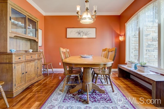 212 S 1st Ave, Escanaba, MI 49829 - dining space featuring wood finished floors, ornamental molding, baseboards, and a chandelier