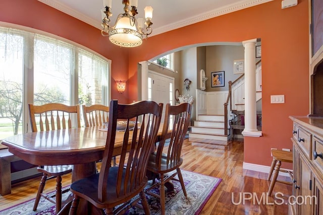 212 S 1st Ave, Escanaba, MI 49829 - dining space with arched walkways, crown molding, light wood-style floors, stairway, and a chandelier