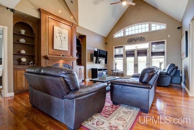 212 S 1st Ave, Escanaba, MI 49829 - living area featuring a fireplace, ceiling fan, high vaulted ceiling, wood finished floors, and built in shelves