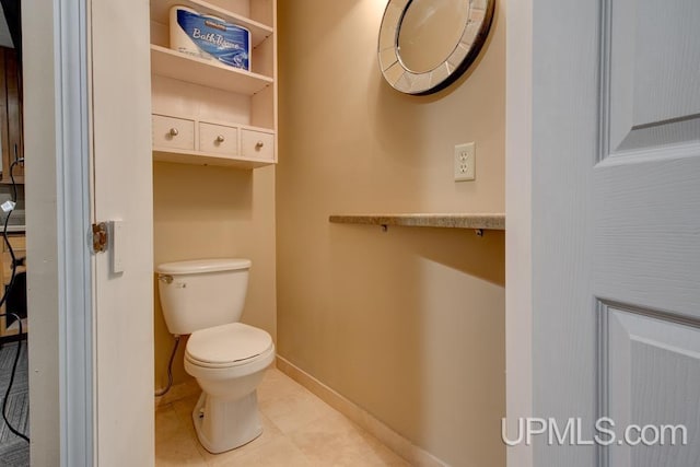 212 S 1st Ave, Escanaba, MI 49829 - bathroom with baseboards, toilet, and tile patterned flooring