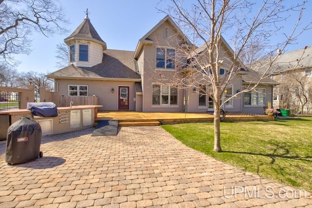 212 S 1st Ave, Escanaba, MI 49829 - rear view of property with a deck, a shingled roof, and a lawn