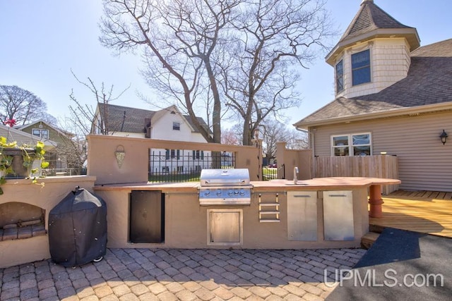 212 S 1st Ave, Escanaba, MI 49829 - view of patio with grilling area, exterior kitchen, a wooden deck, and fence