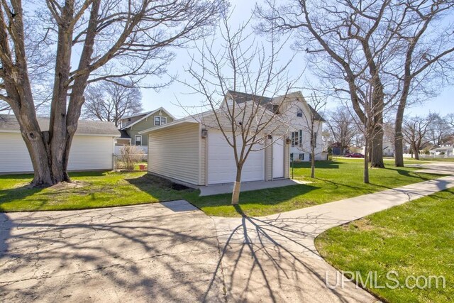 212 S 1st Ave, Escanaba, MI 49829 - view of side of home featuring an outbuilding and a garage