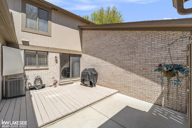 rear view of property featuring central air condition unit, brick siding, and a patio