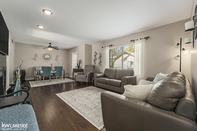 living area with dark wood-type flooring, a ceiling fan, baseboards, and recessed lighting