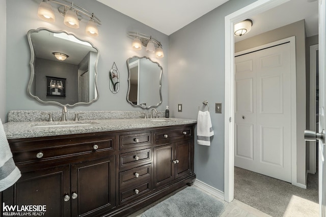 bathroom featuring double vanity and baseboards