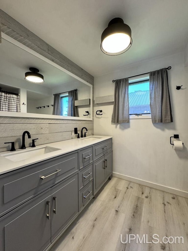 437 N Main St, Lanse, MI 49946 - full bath with tasteful backsplash, wood finished floors, baseboards, and double vanity