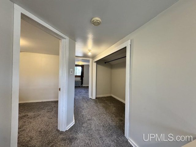 437 N Main St, Lanse, MI 49946 - hall featuring dark carpet, radiator, and baseboards