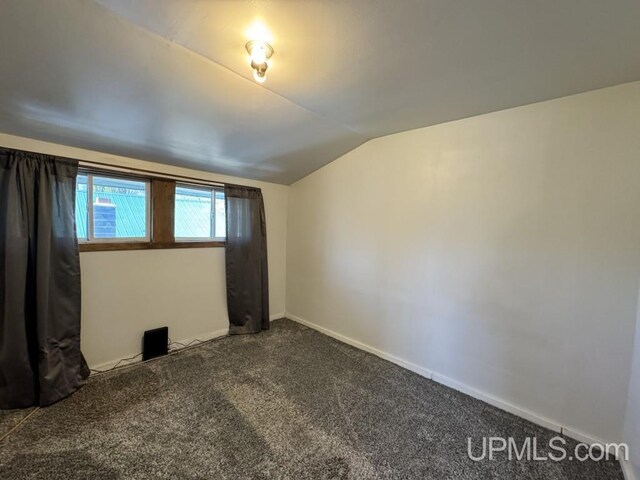 437 N Main St, Lanse, MI 49946 - carpeted empty room featuring lofted ceiling and baseboards