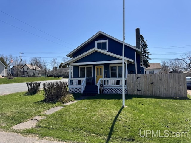 437 N Main St, Lanse, MI 49946 - view of front of house featuring a porch and a chimney