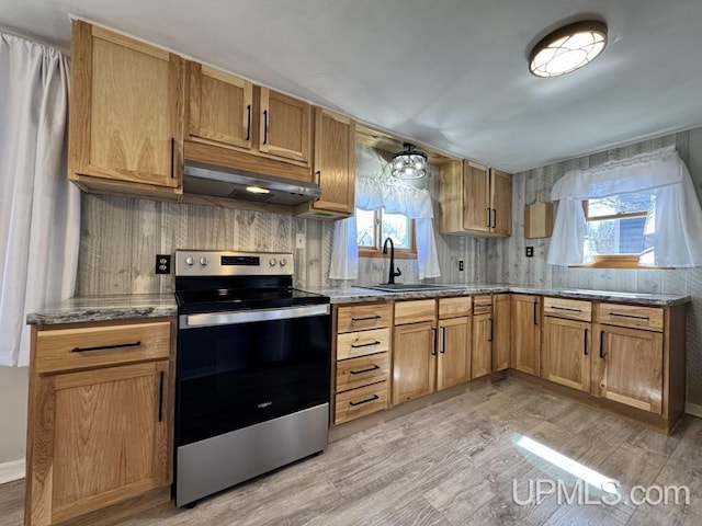 437 N Main St, Lanse, MI 49946 - kitchen with stainless steel electric range oven, under cabinet range hood, a sink, and plenty of natural light