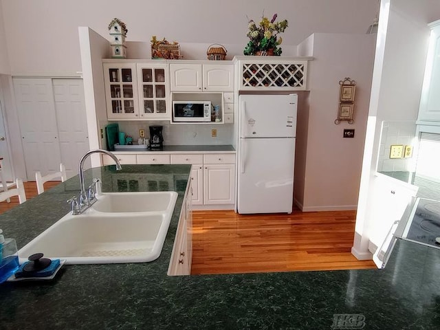 1726 Berkshire Dr, Gladwin, MI 48624 - kitchen with white appliances, a sink, white cabinets, and light wood-style flooring