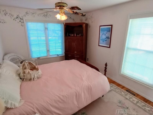 1726 Berkshire Dr, Gladwin, MI 48624 - bedroom with multiple windows, wood finished floors, and ceiling fan