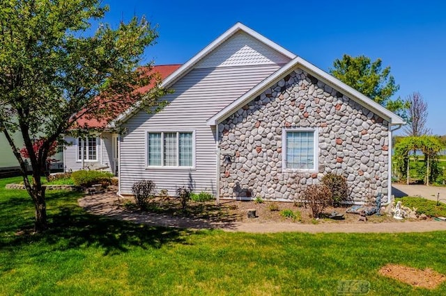 1726 Berkshire Dr, Gladwin, MI 48624 - view of property exterior featuring stone siding and a lawn