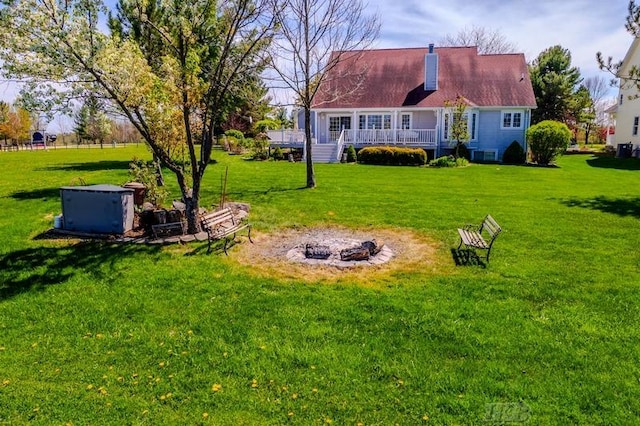 1726 Berkshire Dr, Gladwin, MI 48624 - view of green lawn featuring an outdoor fire pit and a wooden deck