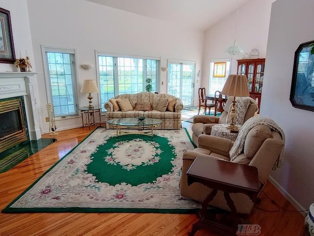 1726 Berkshire Dr, Gladwin, MI 48624 - living room with a fireplace, high vaulted ceiling, wood finished floors, and baseboards