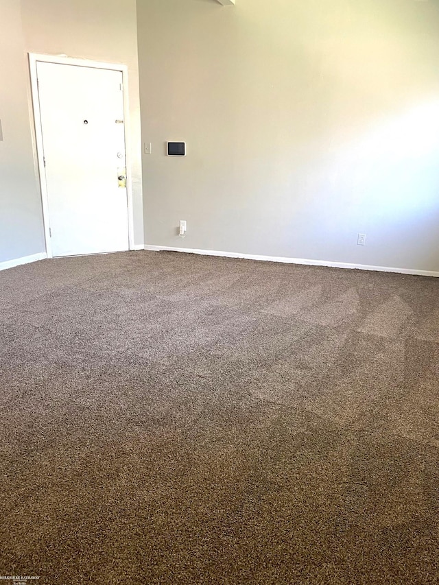 empty room featuring baseboards and carpet floors