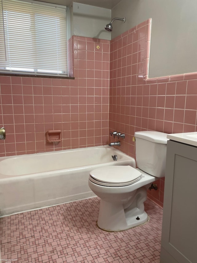 full bathroom with toilet, shower / bath combination, tile walls, vanity, and tile patterned floors