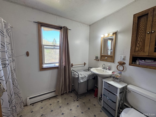 643 S Pine St, Ishpeming, MI 49849 - bathroom featuring a baseboard heating unit, toilet, tile patterned floors, a sink, and a shower with shower curtain