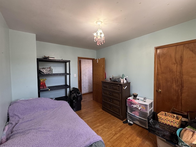643 S Pine St, Ishpeming, MI 49849 - bedroom with light wood-style flooring and a chandelier