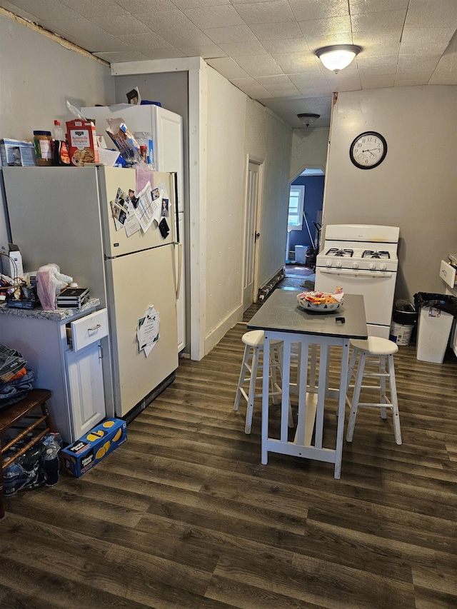 112 Euclid St, Saint Louis, MI 48880 - kitchen with white gas stove, dark wood-style floors, and arched walkways