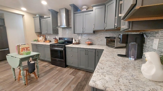 3787 Shepherd Rd, Midland, MI 48880 - kitchen with wall chimney exhaust hood, stainless steel range with gas cooktop, fridge, gray cabinets, and decorative backsplash