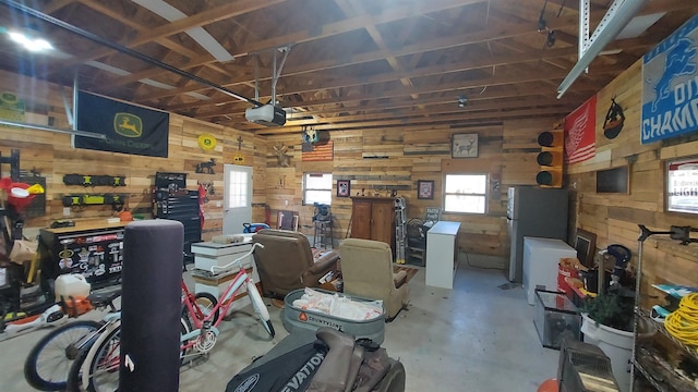 3787 Shepherd Rd, Midland, MI 48880 - garage featuring wooden walls, freestanding refrigerator, and a garage door opener