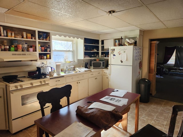kitchen featuring white appliances, open shelves, under cabinet range hood, a paneled ceiling, and light countertops