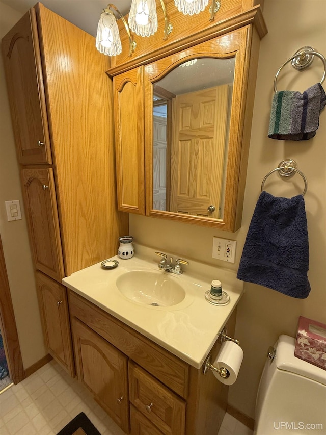 half bathroom featuring vanity and toilet