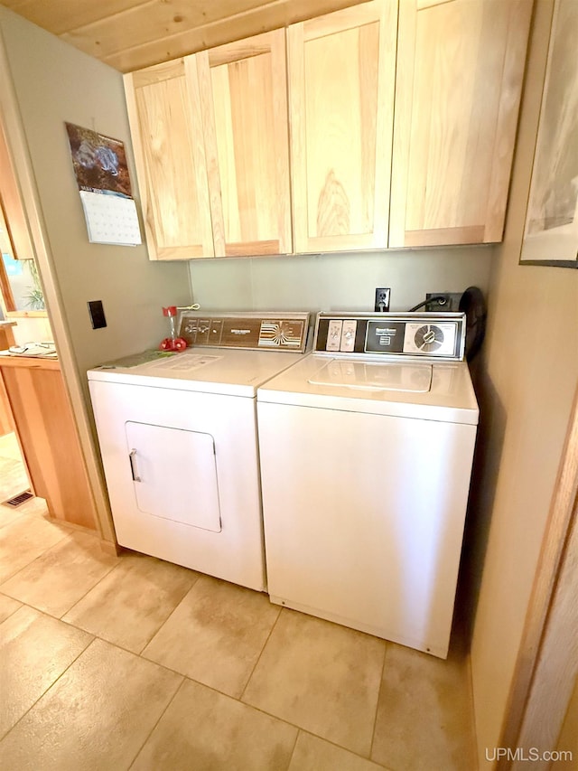 laundry area with washer and dryer, cabinet space, and light tile patterned floors