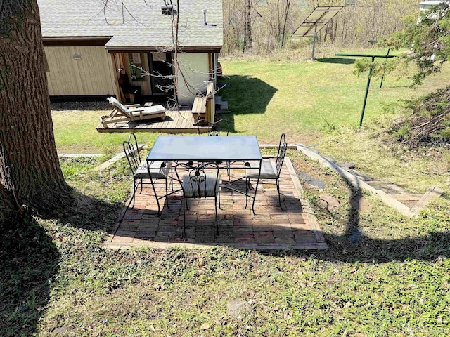 view of grassy yard featuring outdoor dining space and a patio