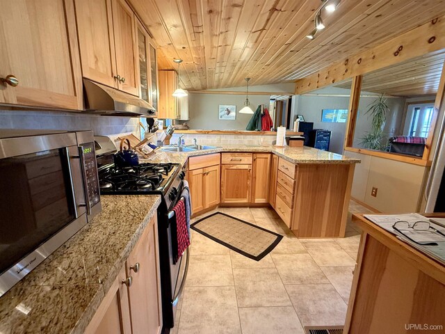 kitchen with appliances with stainless steel finishes, under cabinet range hood, a peninsula, light tile patterned floors, and glass insert cabinets