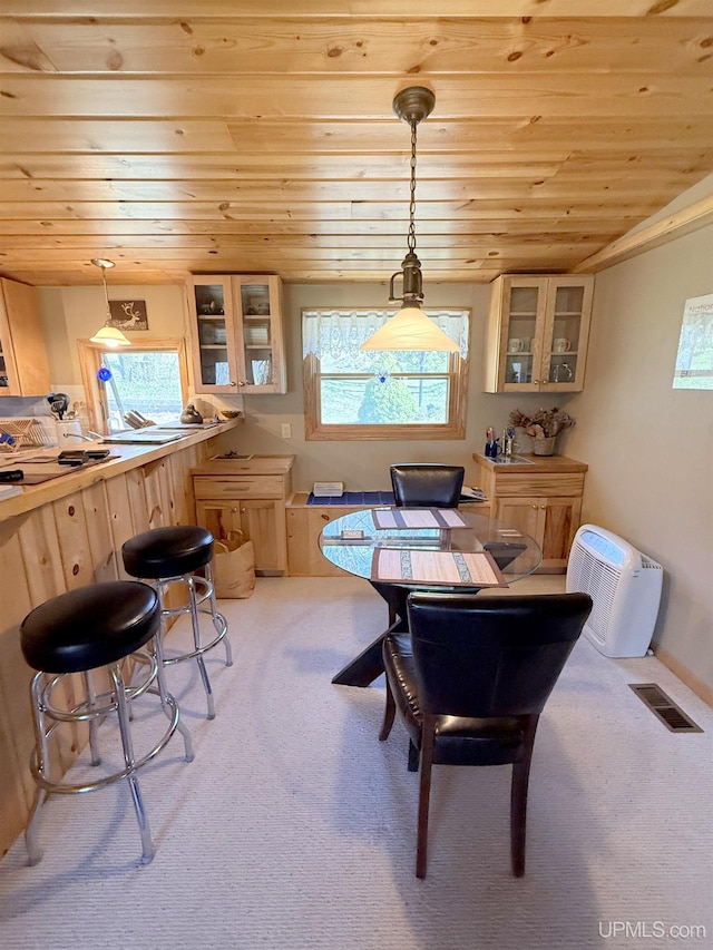 dining space with wood ceiling, plenty of natural light, and light carpet