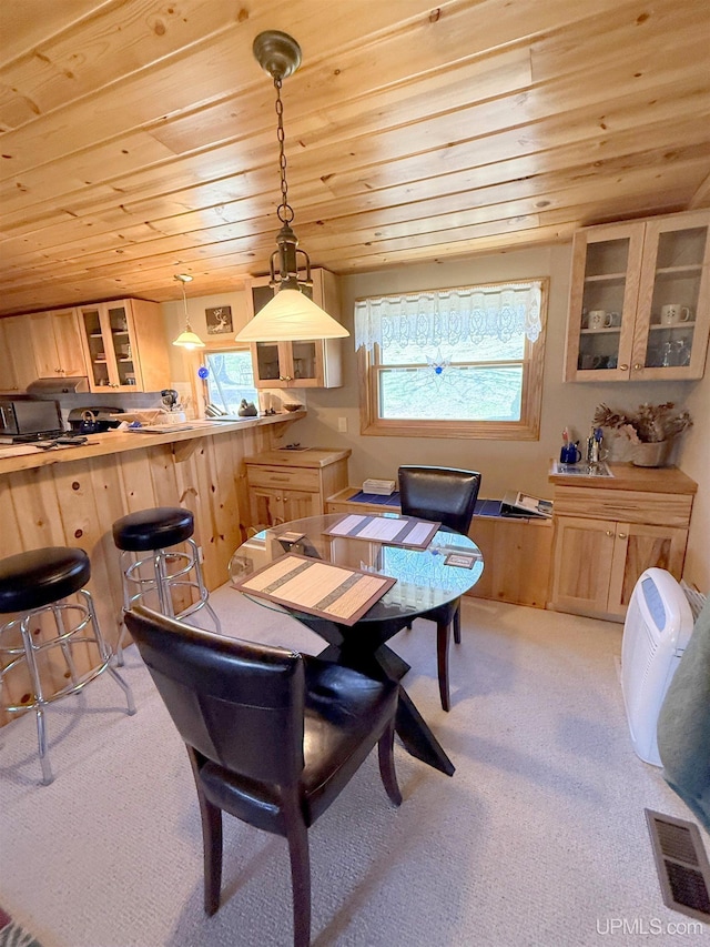 dining space featuring wooden ceiling and light carpet