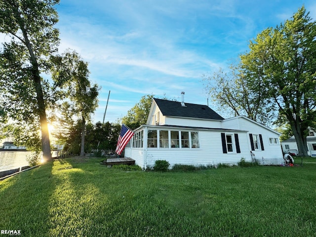 view of home's exterior featuring a lawn and a sunroom