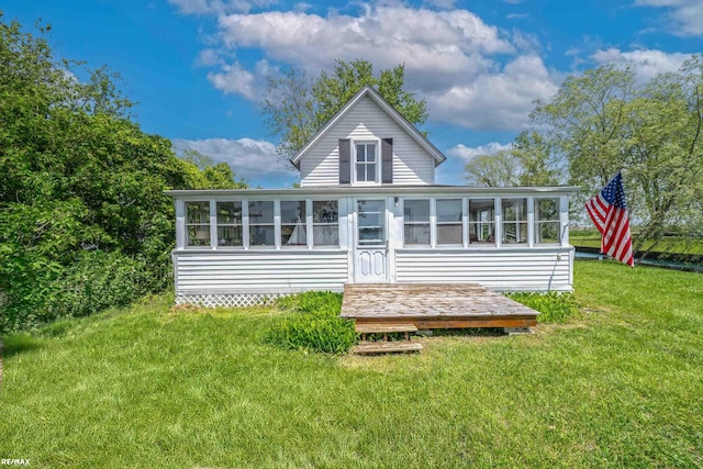 rear view of house with a sunroom and a lawn