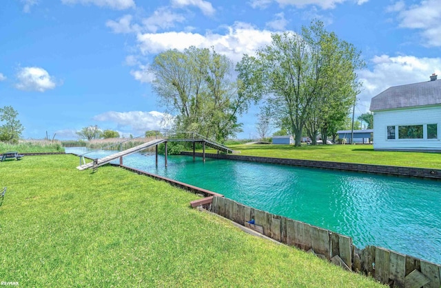 view of swimming pool featuring a yard and a water view