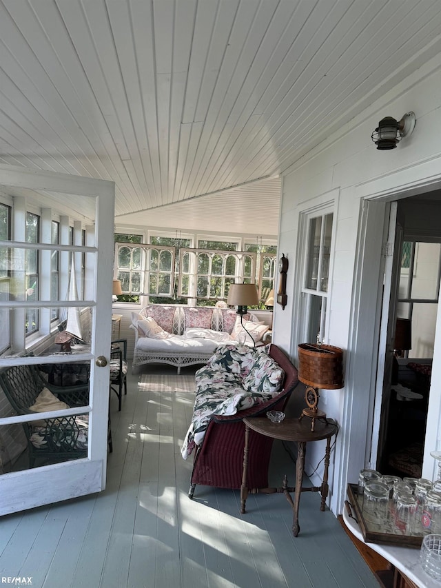 sunroom with healthy amount of natural light, lofted ceiling, wood ceiling, and outdoor lounge area