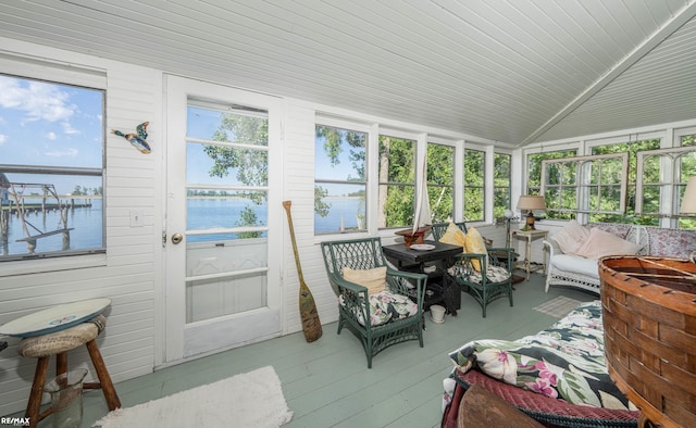 sunroom / solarium featuring a water view and lofted ceiling