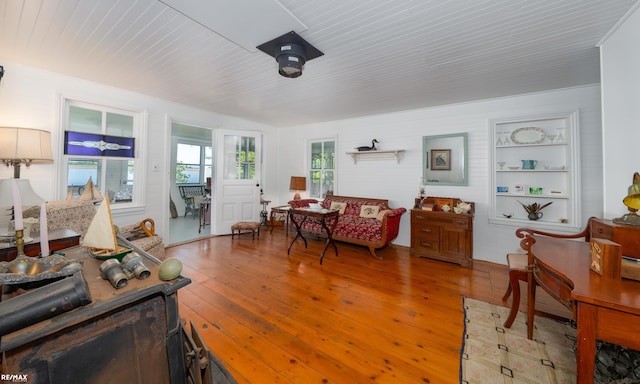 living room featuring hardwood / wood-style flooring, wood ceiling, and built in features