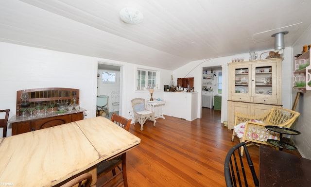 dining space featuring vaulted ceiling and wood finished floors