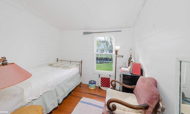 bedroom featuring wood finished floors and vaulted ceiling