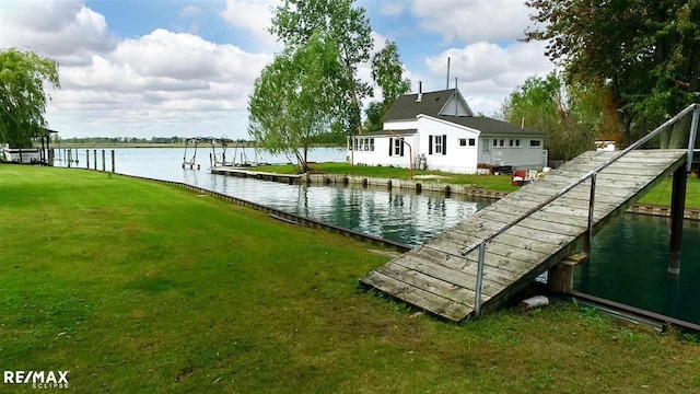 dock area with a water view and a lawn
