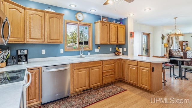 1000 N Evergreen Dr, Iron Mountain, MI 49801 - kitchen featuring appliances with stainless steel finishes, a sink, a peninsula, light wood-style flooring, and ceiling fan