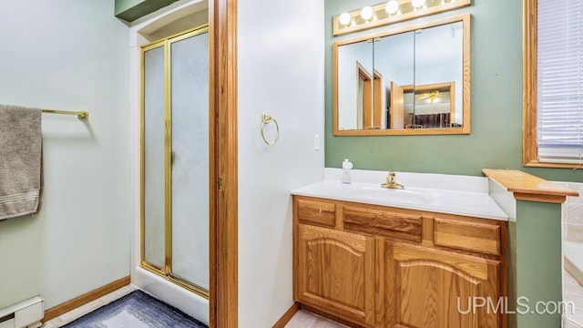 1000 N Evergreen Dr, Iron Mountain, MI 49801 - bathroom featuring a baseboard heating unit, a stall shower, vanity, and baseboards