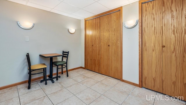1000 N Evergreen Dr, Iron Mountain, MI 49801 - dining space featuring baseboards, light tile patterned floors, and a paneled ceiling
